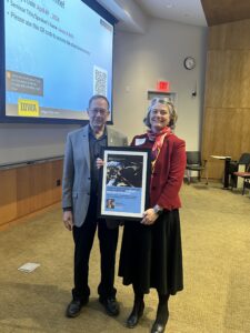 Dr. Christine Petersen presenting Dr. James Roth with his Keynote Speaker Poster, 2024 GPEID Conference
